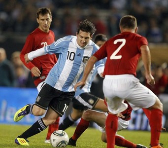 Lionel Messi of Argentina dribbles the ball under pressure from Andi Lila of Albania during their international friendly soccer match in Buenos Aires
