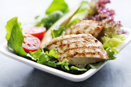 closeup of healthy salad with grilled chicken fillet, selection of lettuce,tomatoes and avocado,